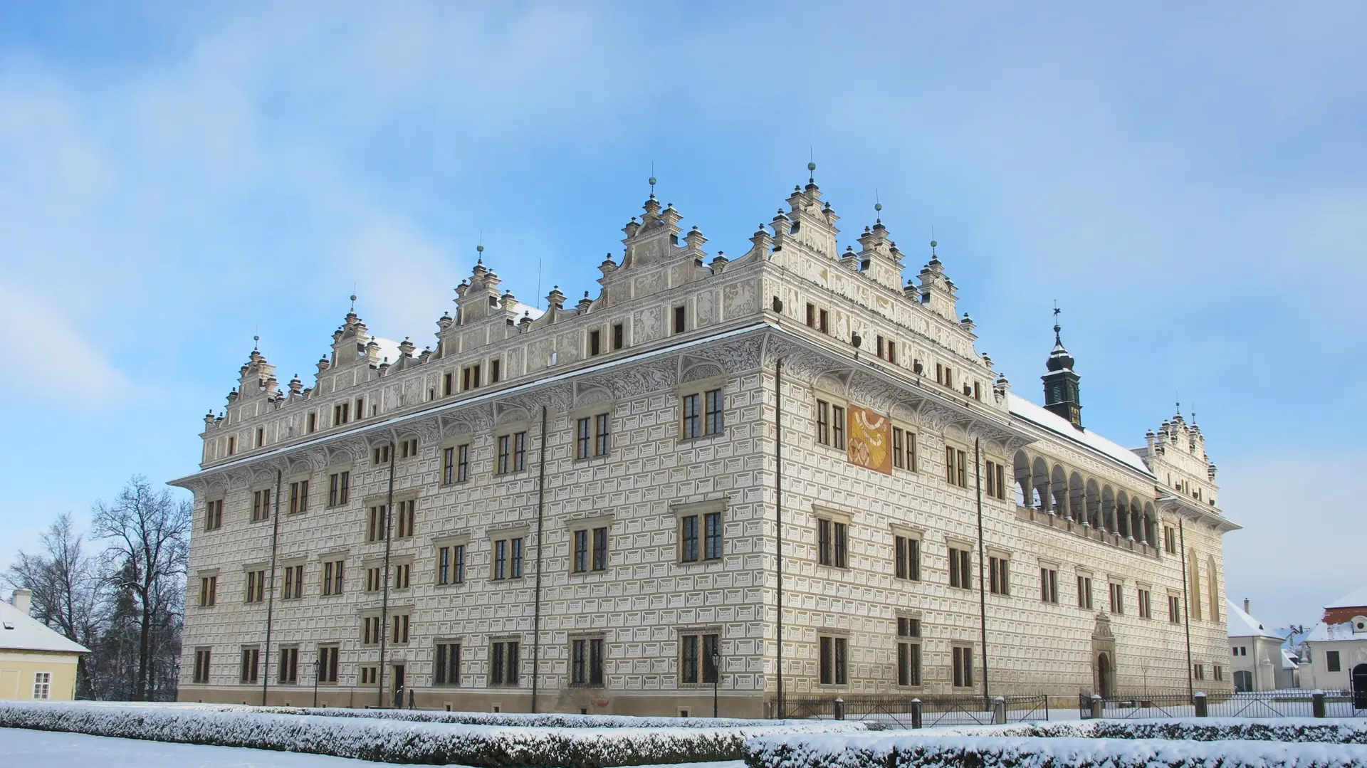 Litomyšl Castle Renaissance arcade courtyard at golden hour in Czech Republic with sgraffito decoration and tower
